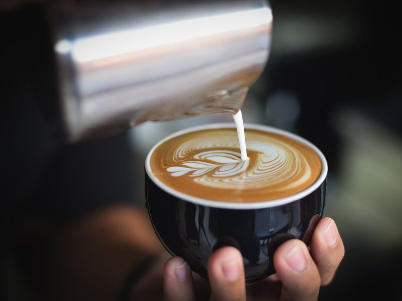 Barista menuang susu untuk latte art