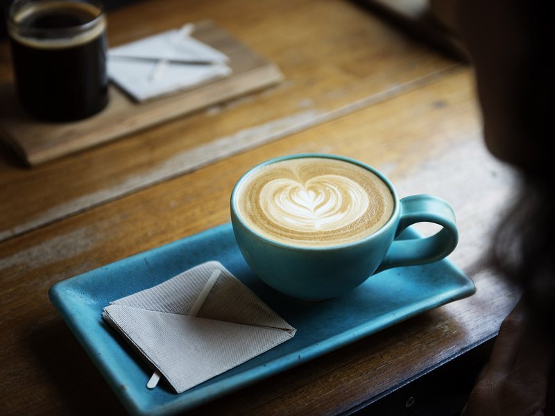 Latte dengan latte art di cangkir biru